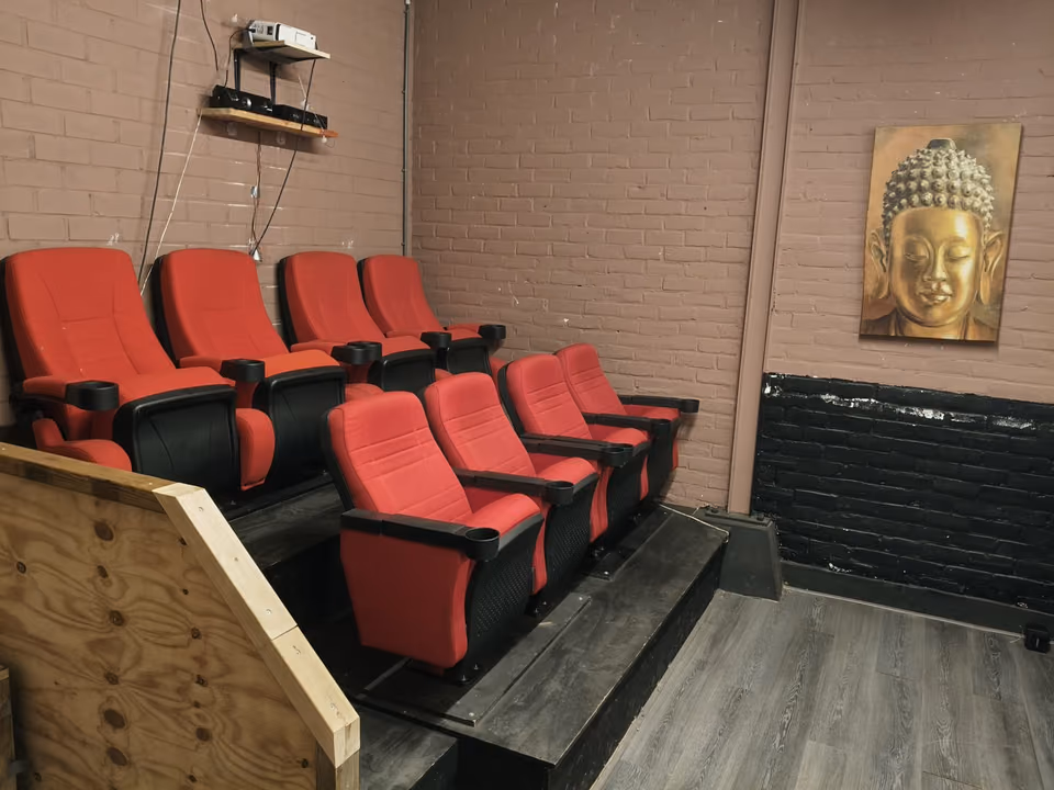 Rijen rode bioscoopstoelen in een kleine zaal