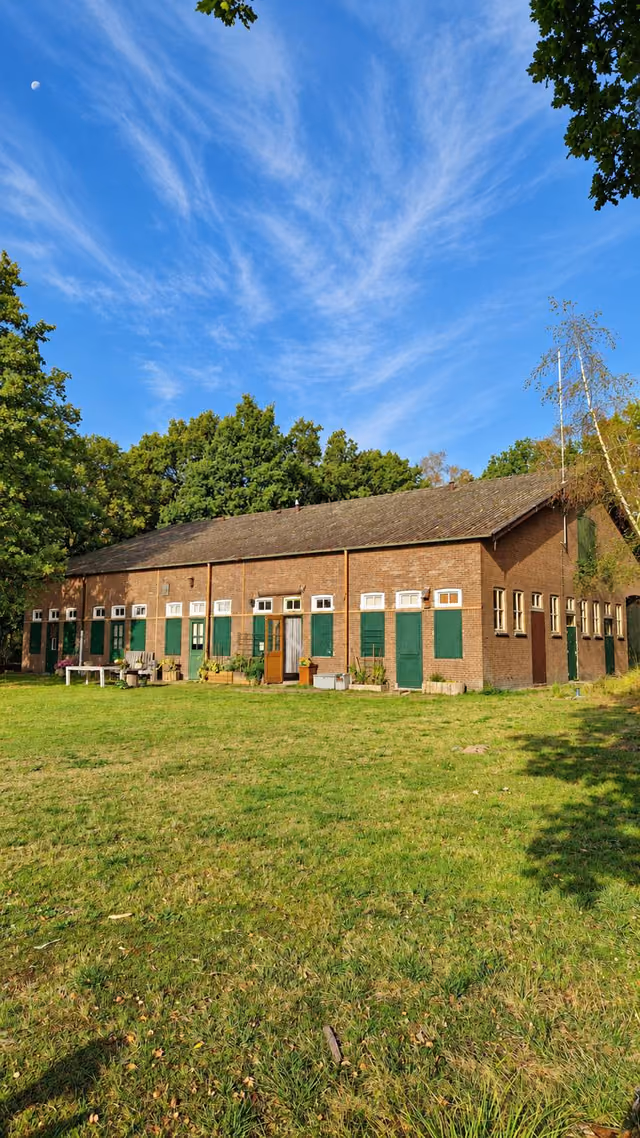 Het gebouw van Mariapeel gezien vanaf het grasveld, onder een blauwe lucht