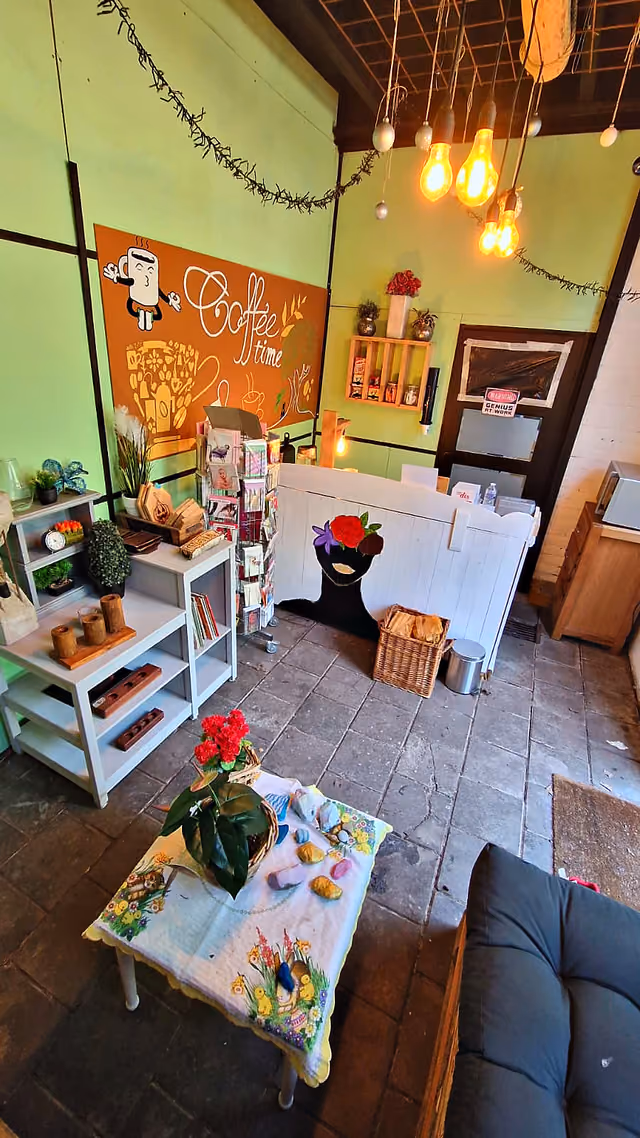 De huiskamer met zitbank, planten en het krijtbord met koffie