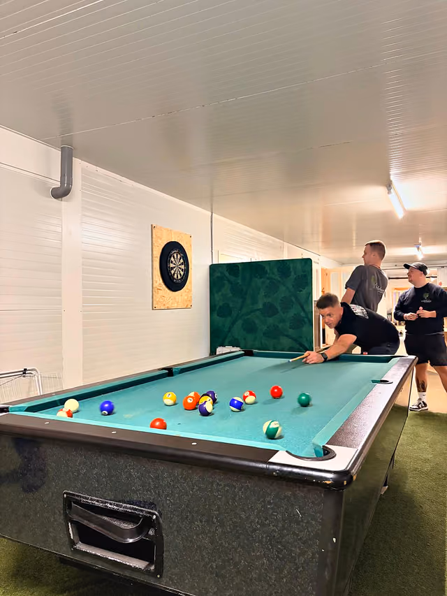 Deelnemers spelen pool in de ontspanningsruimte
